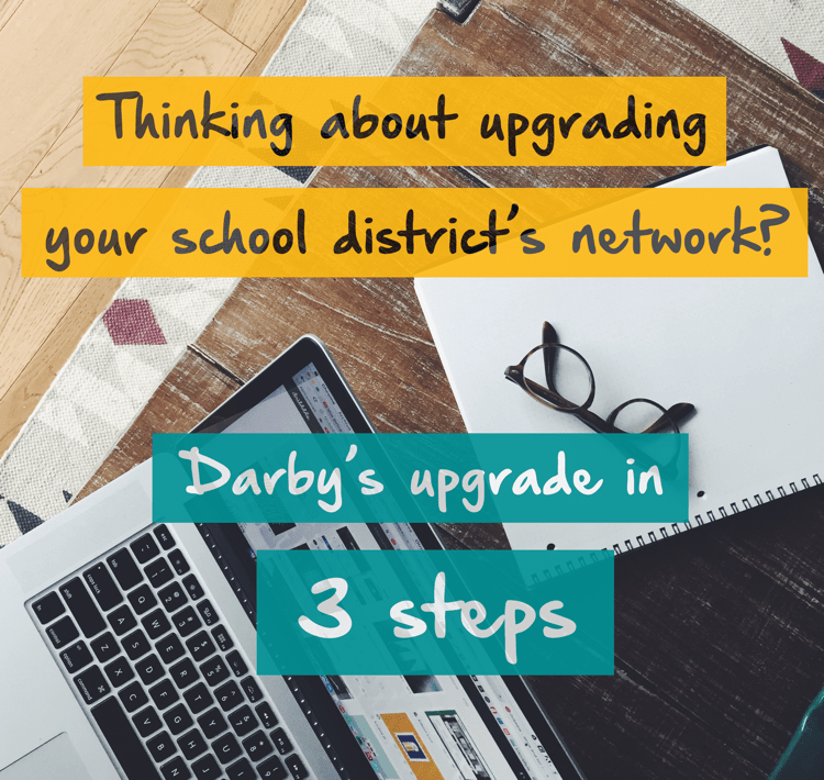 Ariel view of computer, notepad and glasses on a wood table with the words "Thinking about upgrading your school district's network? Darby's upgrade in 3 steps" written on top of the image