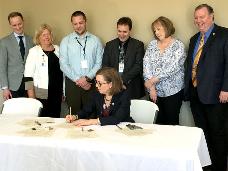 Oregon Governor Kate Brown signing a bill