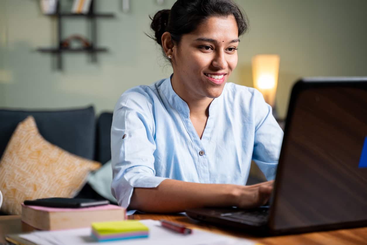 Young woman busy working on laptop at home